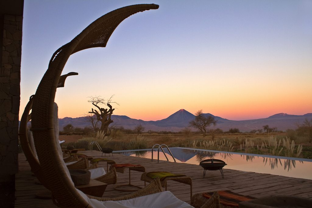 Pool with volcano in the background at sunset