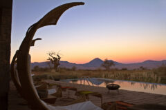 Pool with volcano in the background at sunset