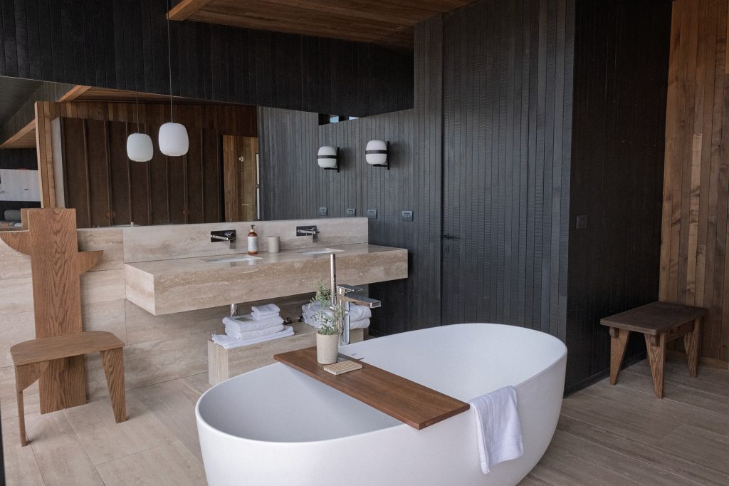 Suite bathroom with a bathtub and two sinks