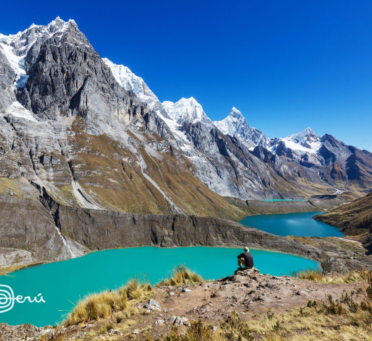 A hiker staring out at a lake in the Cordillera Huayhuash region