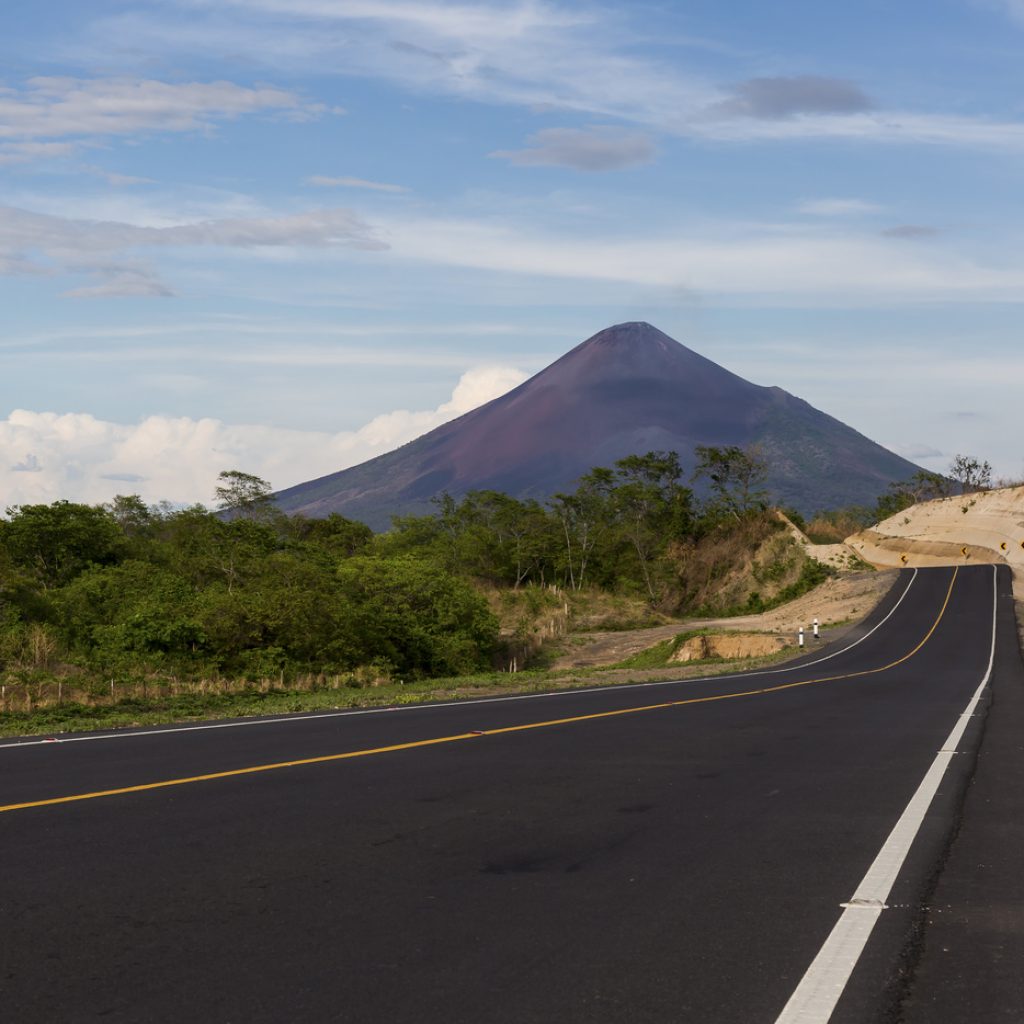 Tarmac road heading towards tall mountain
