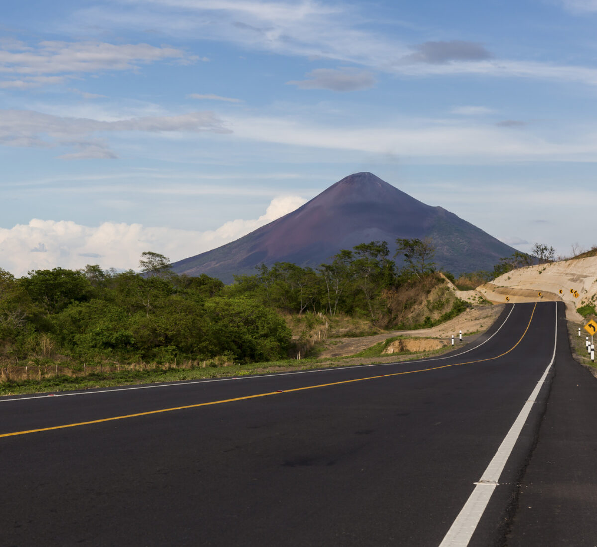 Tarmac road heading towards tall mountain