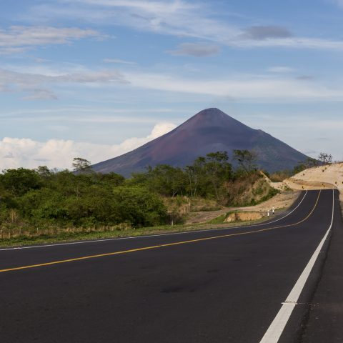 Tarmac road heading towards tall mountain