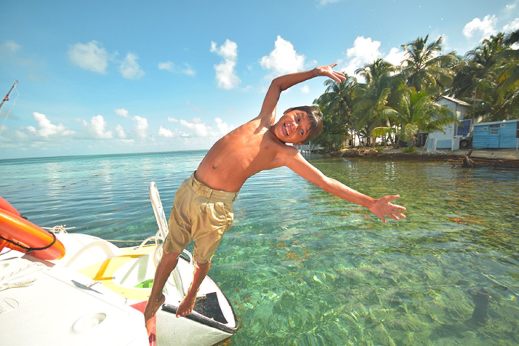 Kid jumping off a boat into water