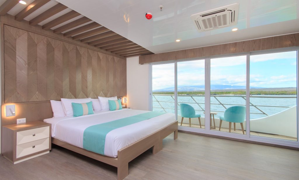 Golden suite with double bed and deck with chairs.