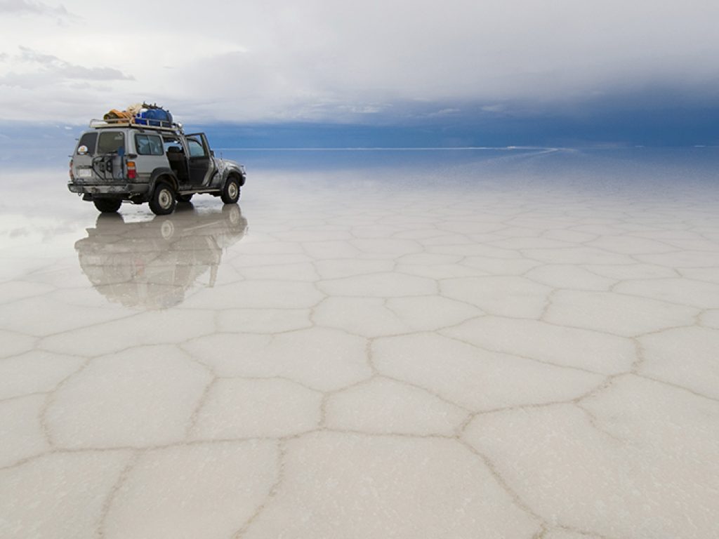 jeep in the salt lake salar de uyuni, bolivia